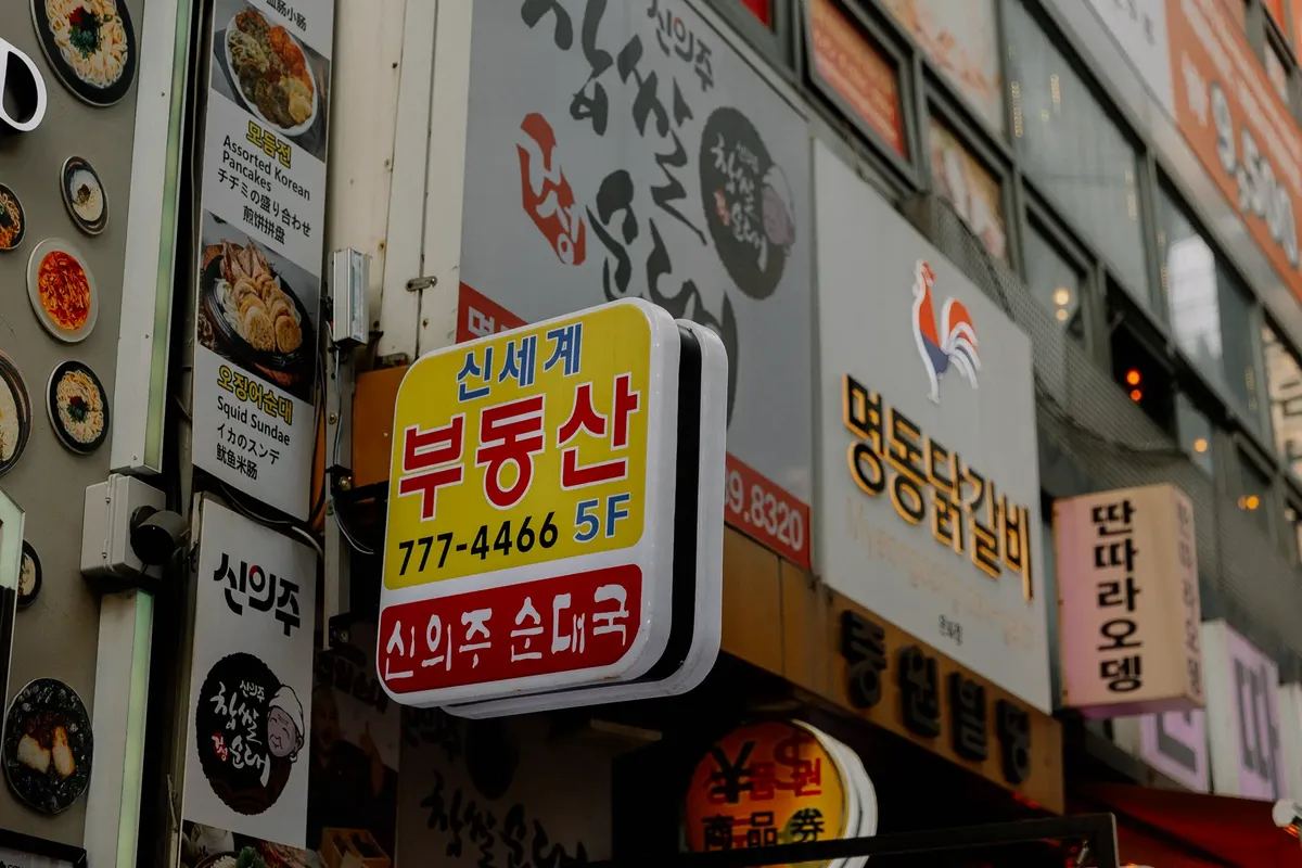 にぎやかな韓国街の路上にある明るい看板とレストランのフロント