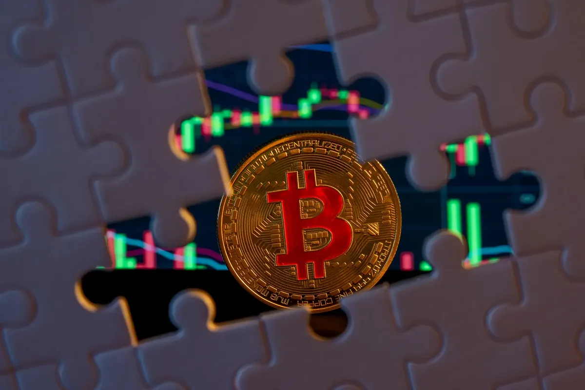 ビットコインコインが株式市場グラフに重なったパズルにフィットしている。暗号通貨投資を象徴している。