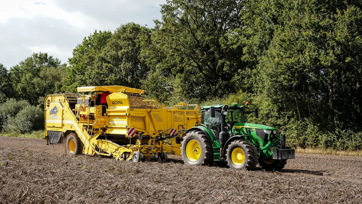 Agricultural machinery working in a field in Sauensiek, Niedersachsen, Germany, showcasing modern farming technology.